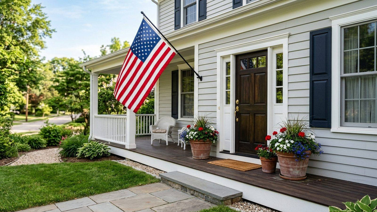 American flag flying from a wall bracket on a clean front porch in morning light