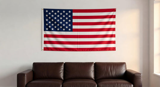 American flag hanging on indoor wall above brown leather sofa