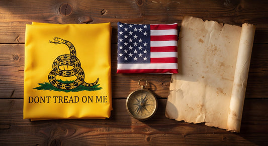 Gadsden flag with coiled rattlesnake, folded American flag, antique compass, and old parchment on wood