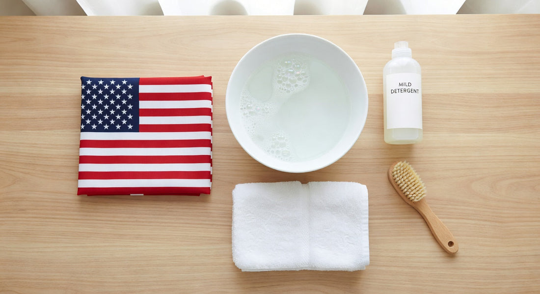 Folded American flag, bowl with soapy water, mild detergent, towel, and brush on wood table