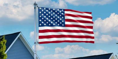 American flag flying on a residential flag pole against a blue sky
