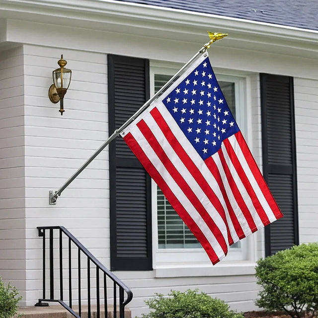 American flag mounted on a white house with black shutters, outdoor home setting