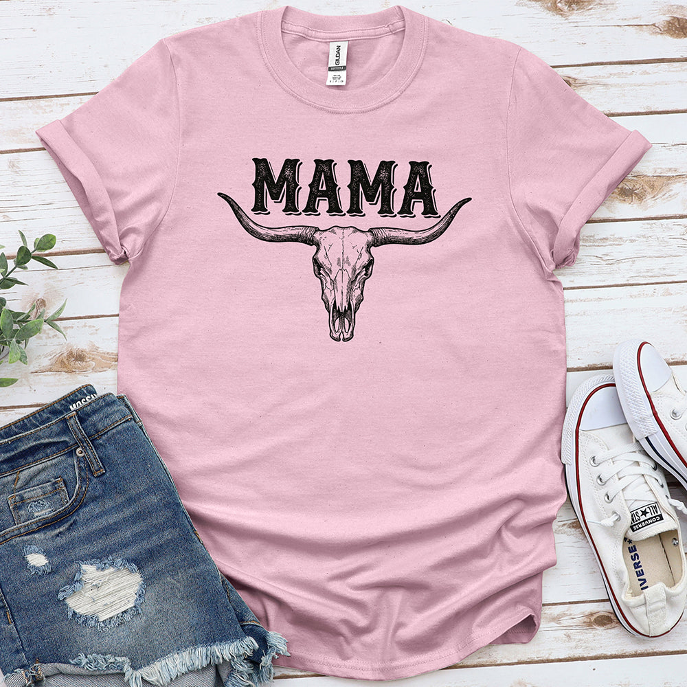 Light pink t-shirt with 'MAMA' text and bull skull graphic, styled with denim shorts and sneakers