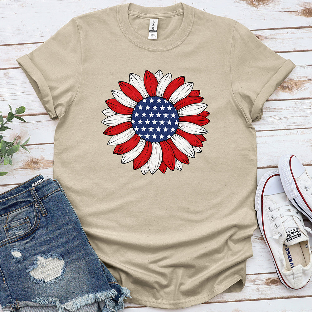 Beige t-shirt with sunflower graphic in American flag colors, styled with denim shorts and sneakers