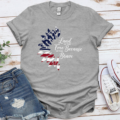 Grey patriotic t-shirt with American flag feather design and 'Land of the Free Because of the Brave' text