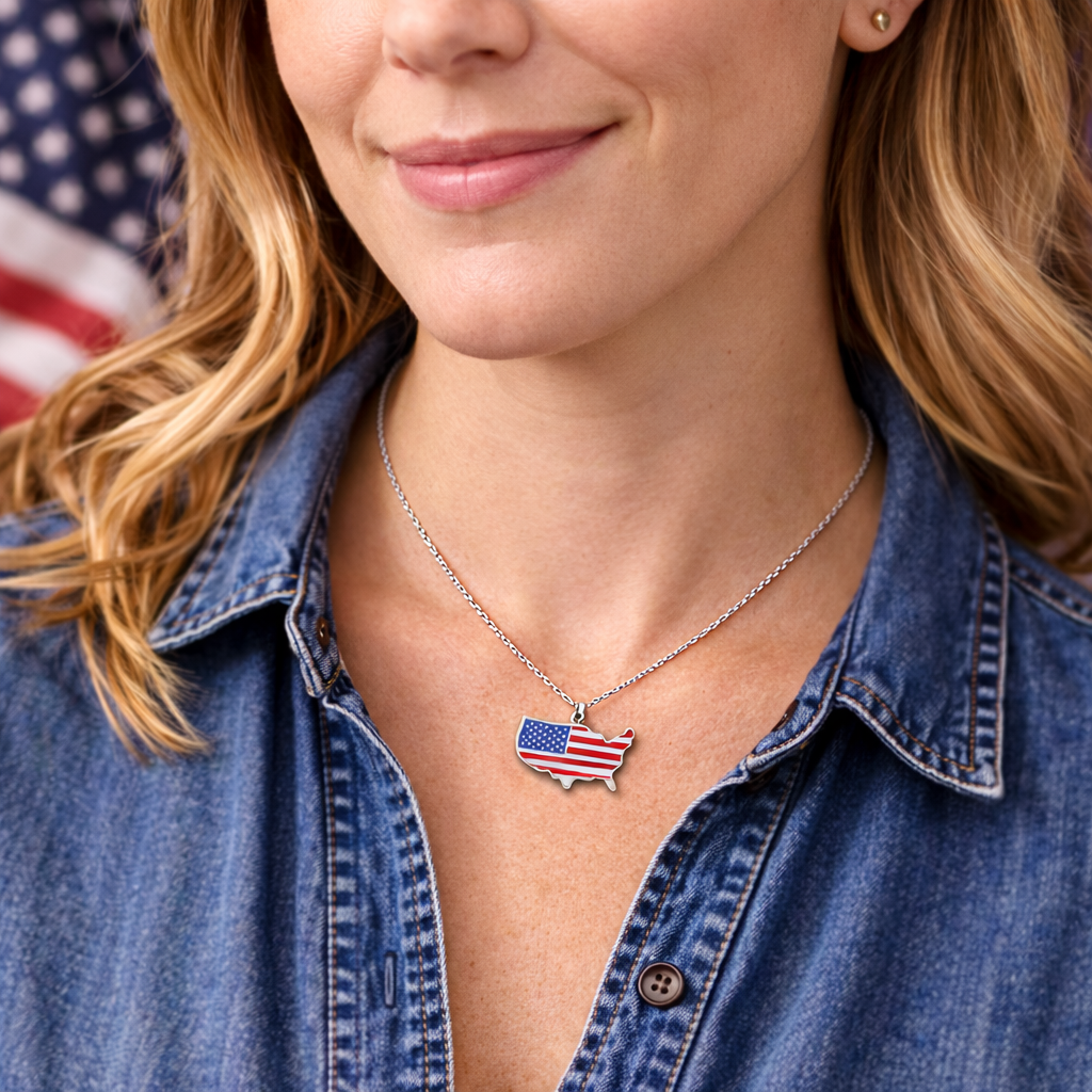 Woman in denim shirt wearing USA flag pendant necklace, American flag in background