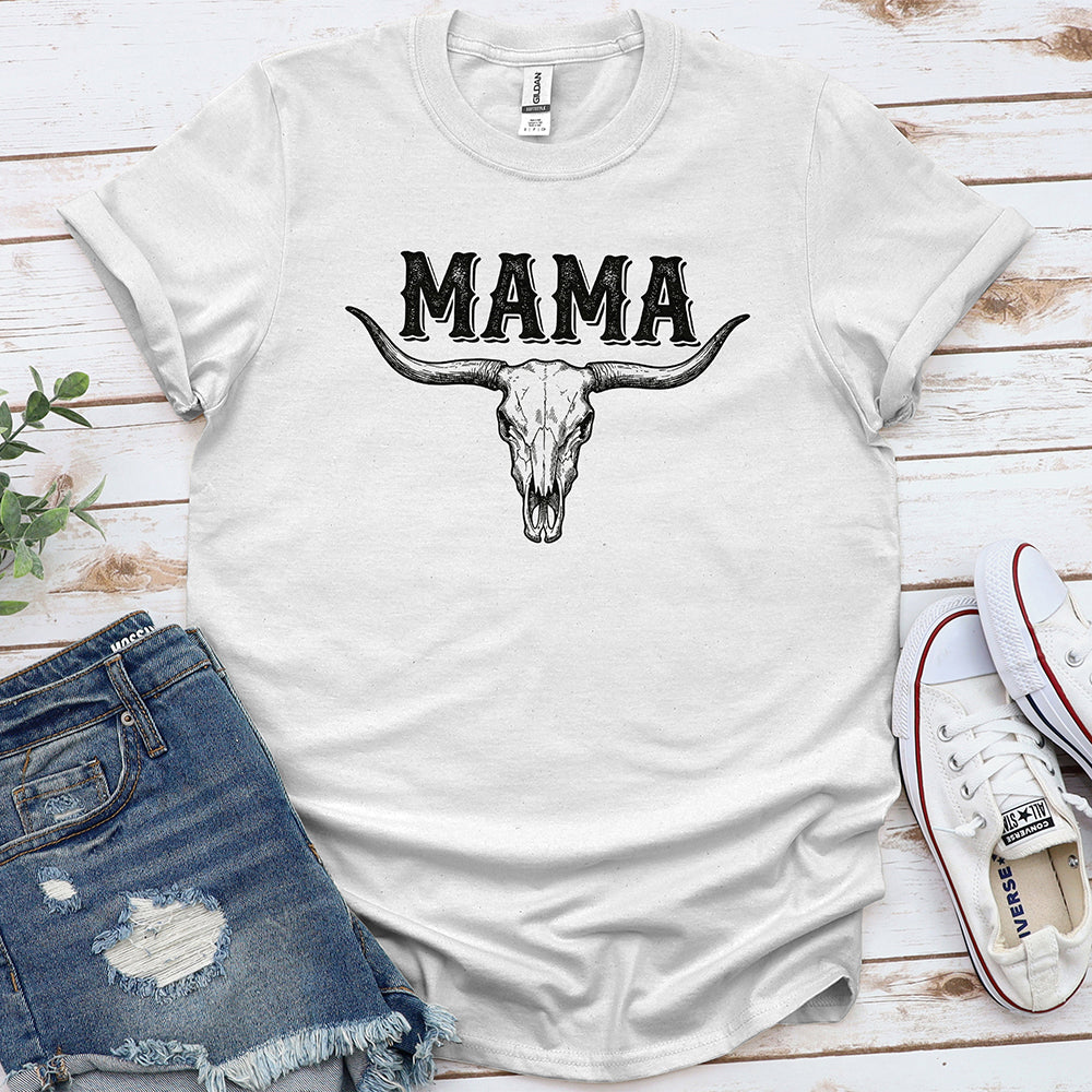White graphic tee with 'MAMA' text and bull skull, styled with denim shorts and sneakers
