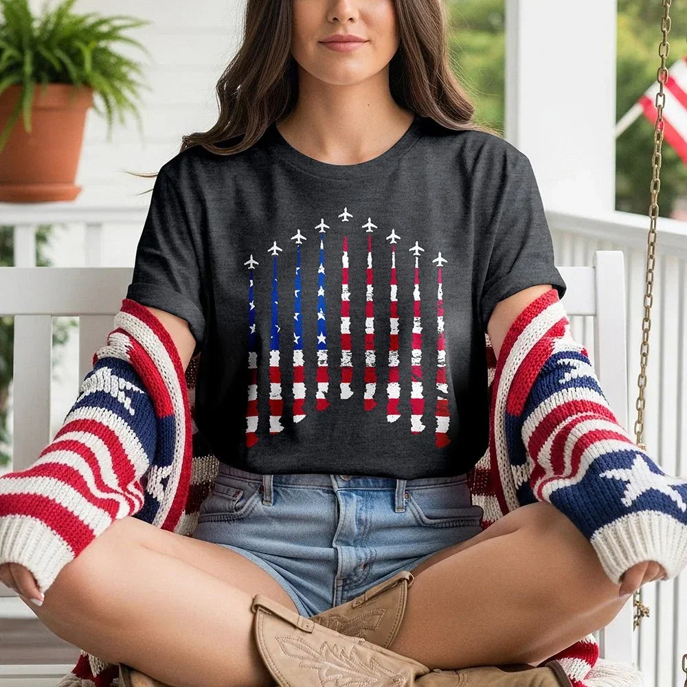Woman wearing Proud & Free airplane smoke tee with American flag, sitting on porch swing.