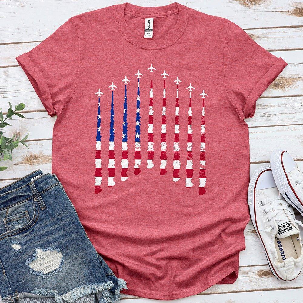 Red Proud & Free tee with airplane smoke American flag design, laid flat with jeans and sneakers