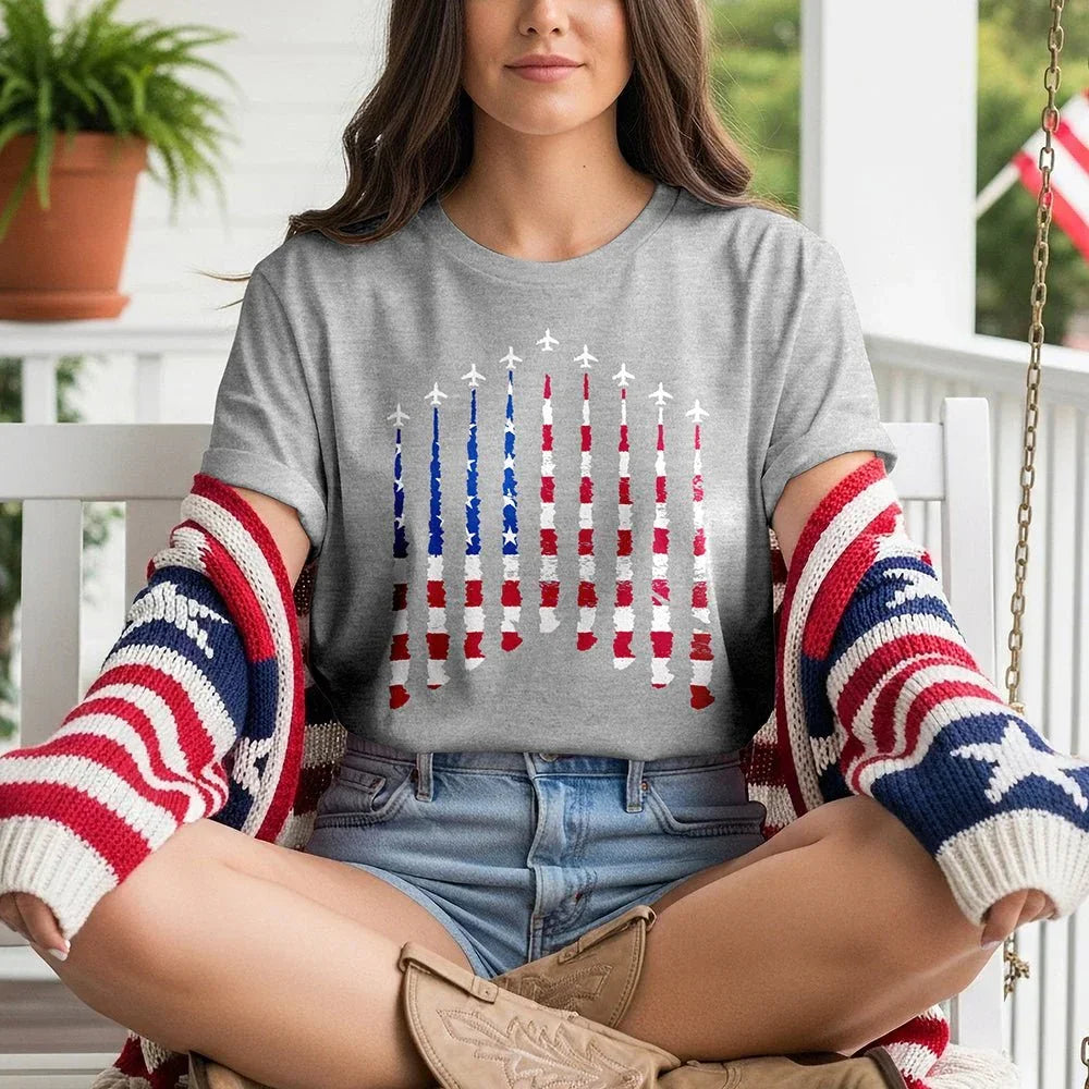 Woman wearing Proud & Free gray tee with airplane smoke American flag design, patriotic sweater