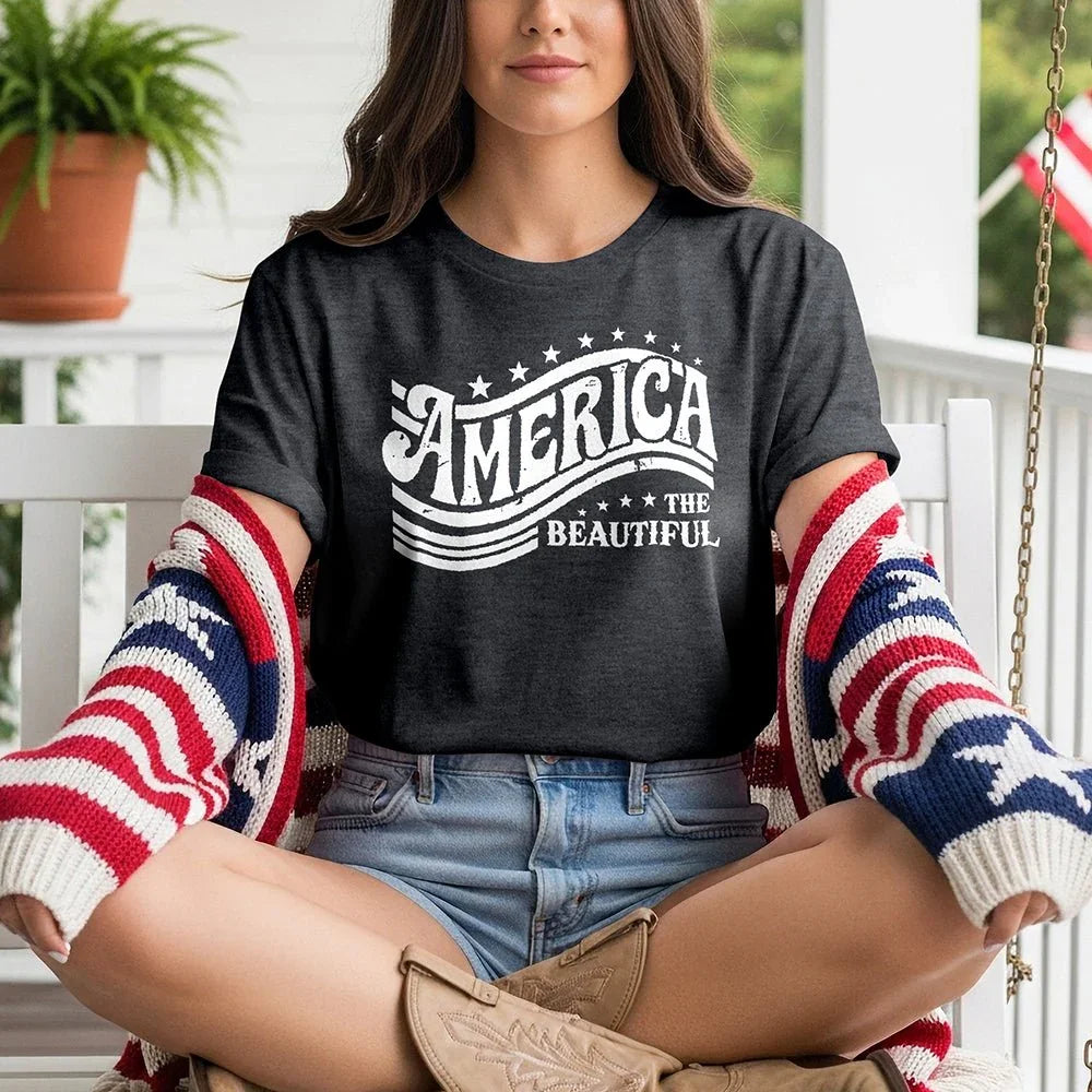 Woman on porch in 'America the Beautiful' tee, patriotic cardigan, denim shorts, western boots