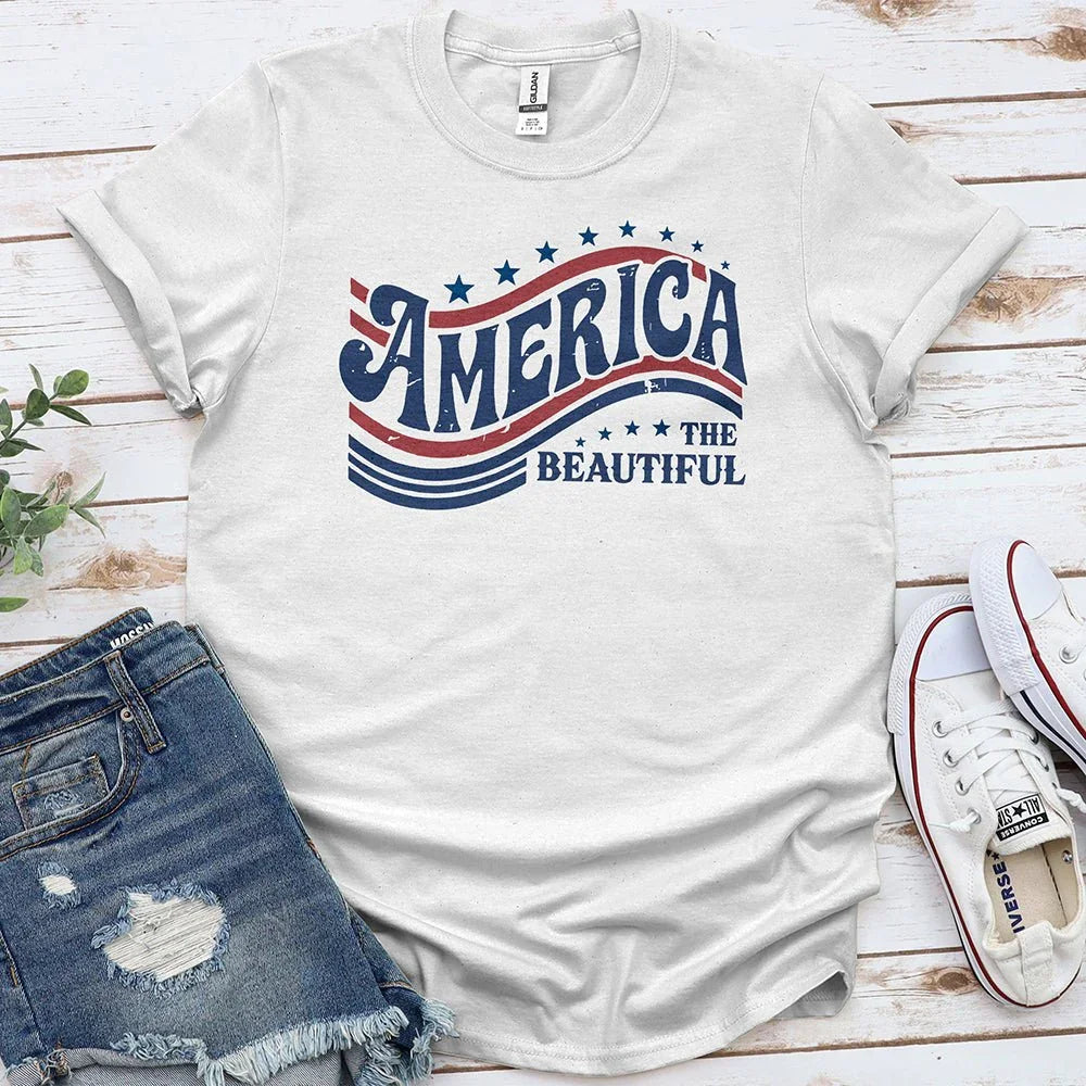 America the Beautiful graphic tee with patriotic stars, paired with denim shorts and white sneakers