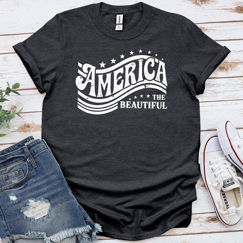 America the Beautiful graphic tee on wooden background with denim shorts and white sneakers