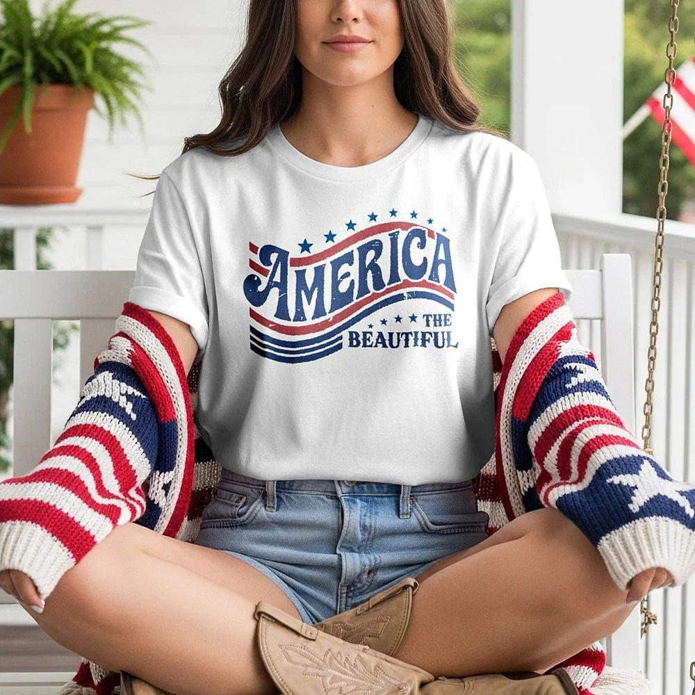 Woman on porch wearing 'America the Beautiful' t-shirt with patriotic cardigan and boots