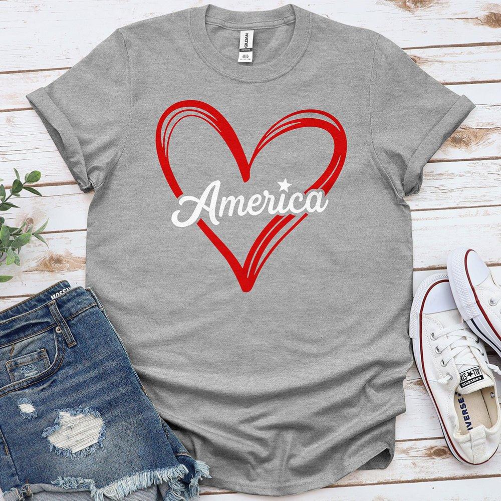 Gray t-shirt with red heart and America text, styled with denim shorts and white sneakers.