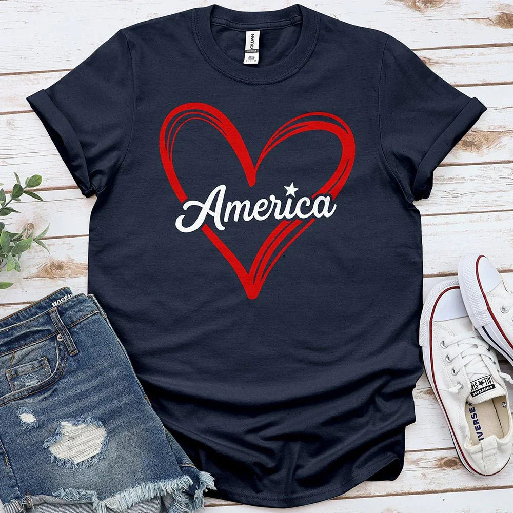 Navy t-shirt with red heart and 'America' text, styled with denim shorts and sneakers