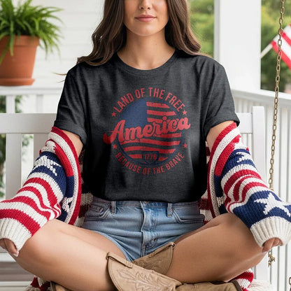Woman wearing Land of the Free America t-shirt and patriotic sweater on porch swing