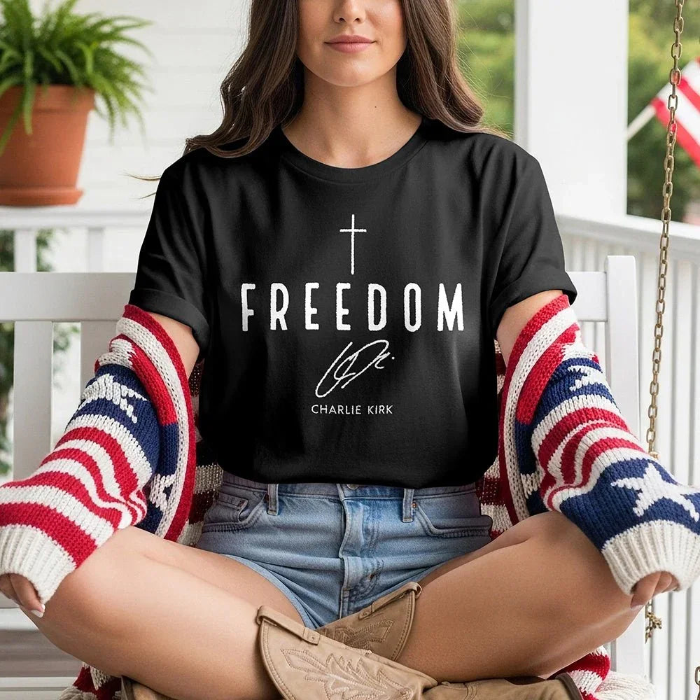 Woman in Proud & Free Freedom Tee, patriotic cardigan, sitting on porch swing