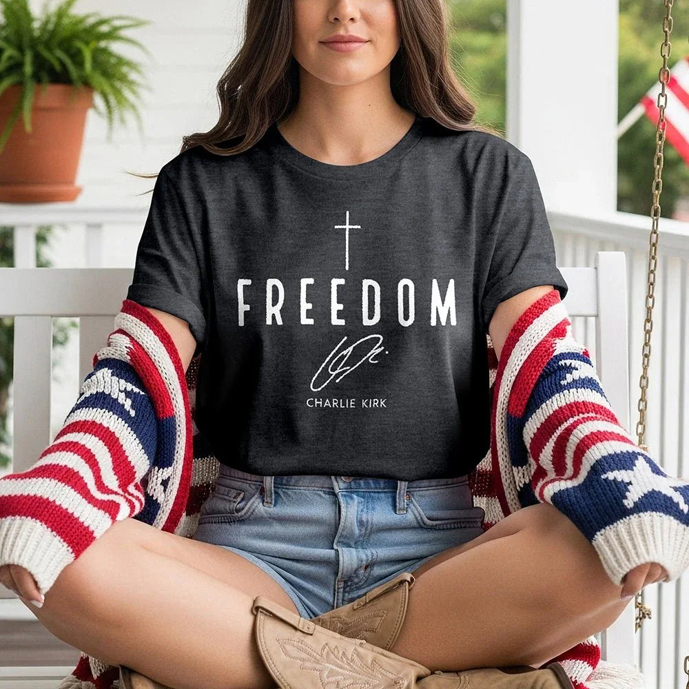 Woman wearing Freedom graphic tee, American flag sweater, sitting on porch swing