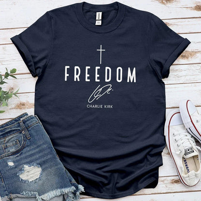 Navy blue Freedom tee with white cross and signature, styled with denim shorts and Converse shoes