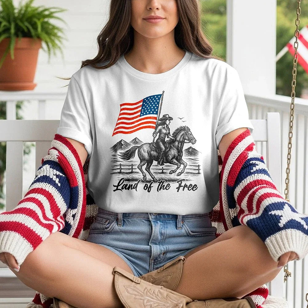 Woman in patriotic cardigan wears 'Land of the Free' tee with cowboy, horse, American flag graphic