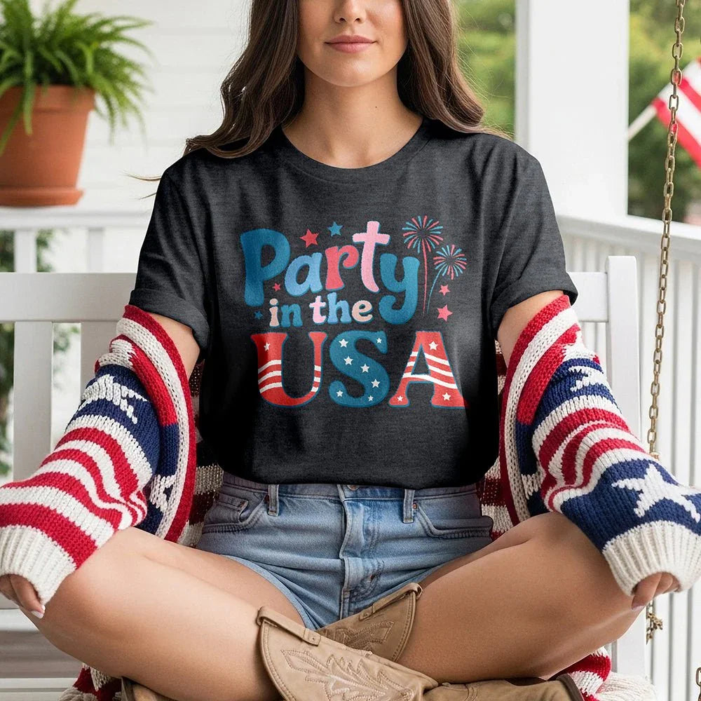 Woman on porch wearing 'Party in the USA' t-shirt, patriotic cardigan, and cowboy boots