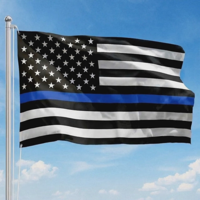 Thin Blue Line American flag waving on a flagpole against a blue sky