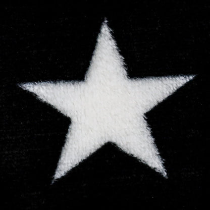 Close-up of soft plush blanket with white star on black background, Proud & Free decor