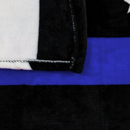 Close-up of soft plush blanket with thin blue line and black, white, and blue stripes