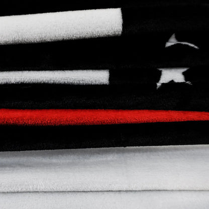 Thin red line plush blanket with black, white, and red stripes and white star accents.