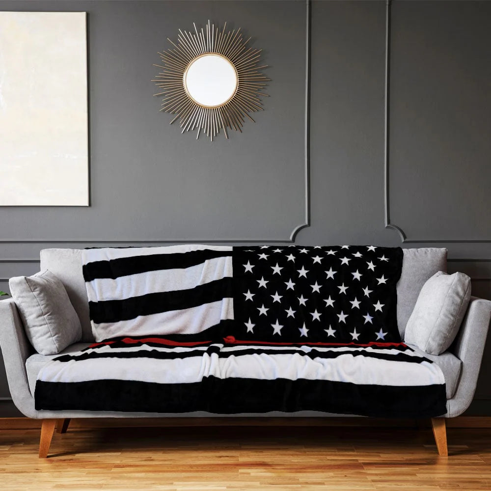 Thin red line American flag plush blanket on modern gray sofa in living room