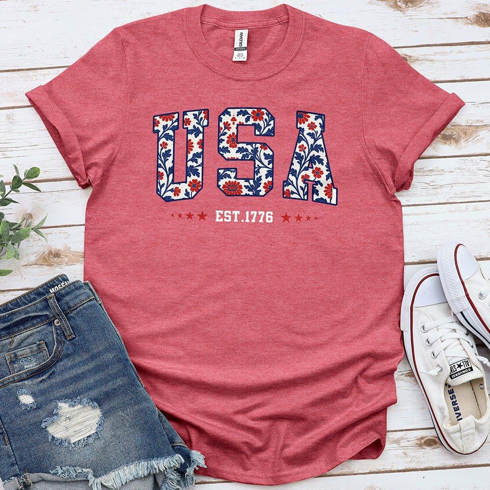 Pink Proud & Free tee with floral USA print, EST. 1776, laid with denim shorts and sneakers